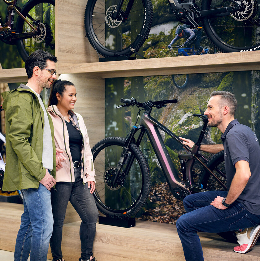 a couple shopping for ebikes consults with an associate at the dealer