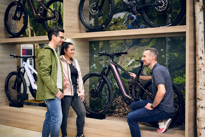 a couple shopping for ebikes consults with an associate at the dealer