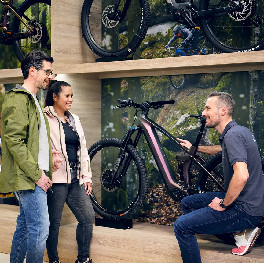 a couple shopping for ebikes consults with an associate at the dealer