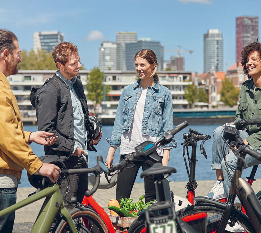 Four people stop with their bikes waterside for a chat in Rotterdam