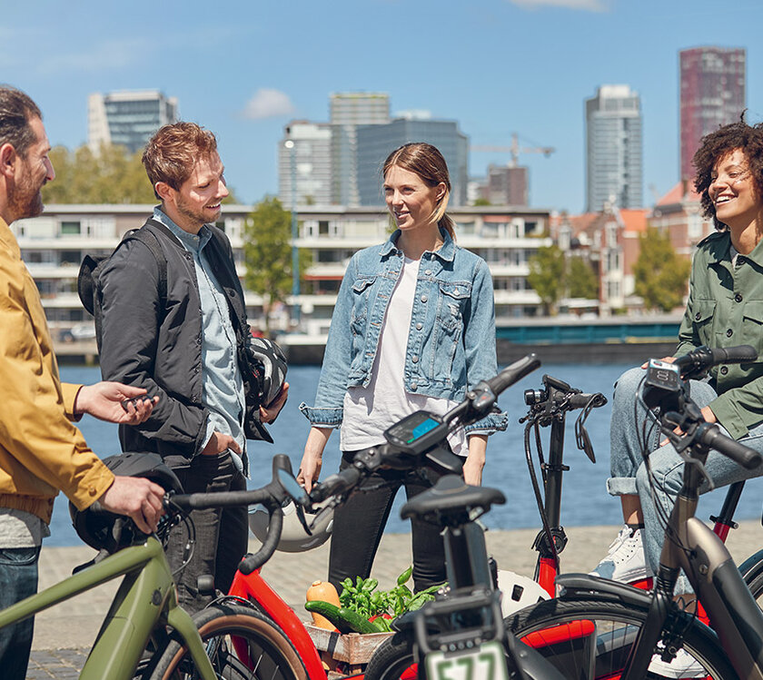 Four people stop with their bikes waterside for a chat in Rotterdam