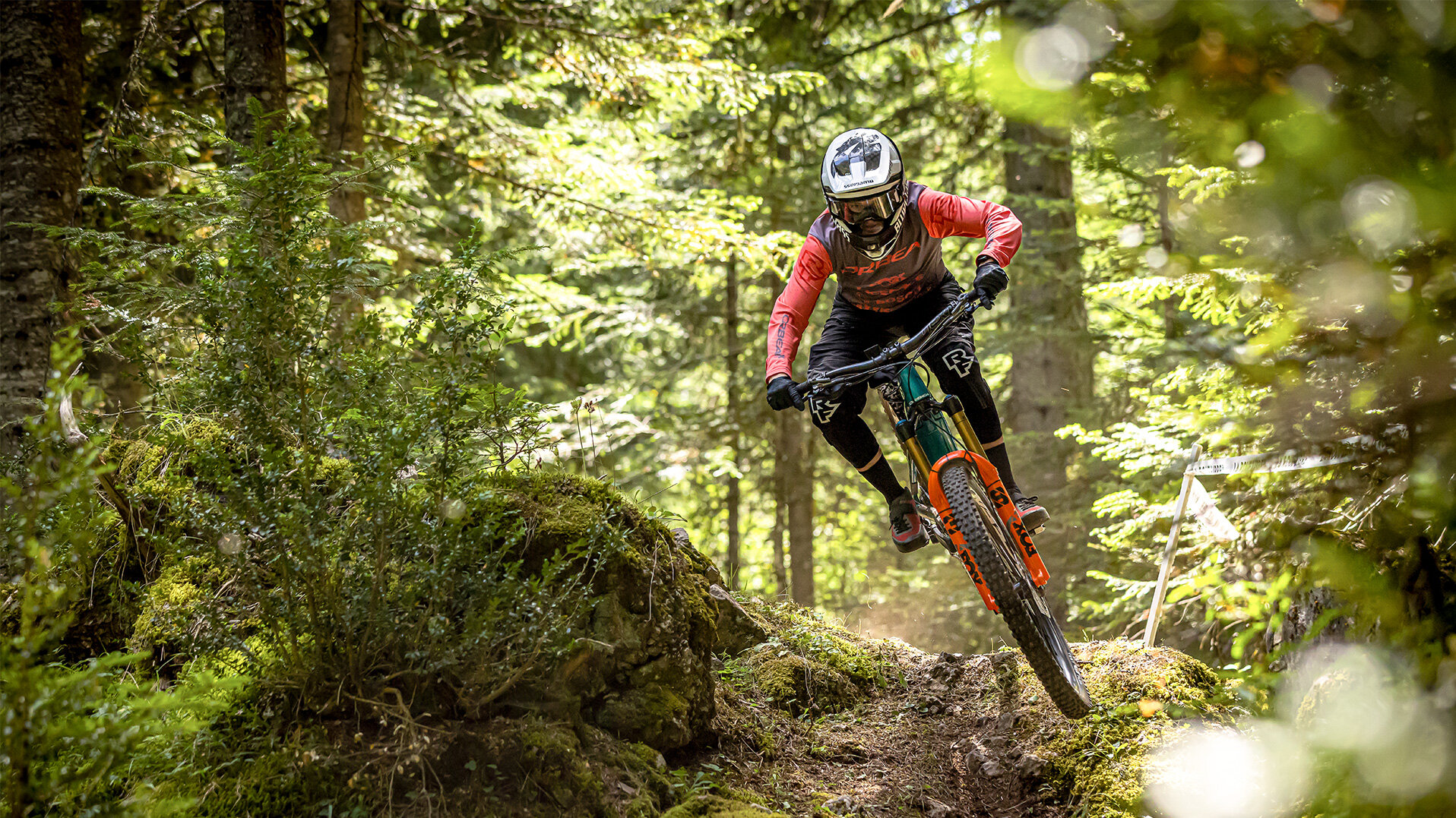 Un eMTB-Fahrer percorre veloce un Trail attraverso il bosco lungo.