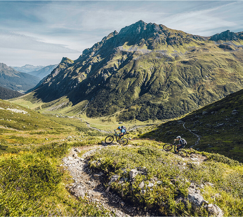 Two eBike riders on a rocky trail in the mountains