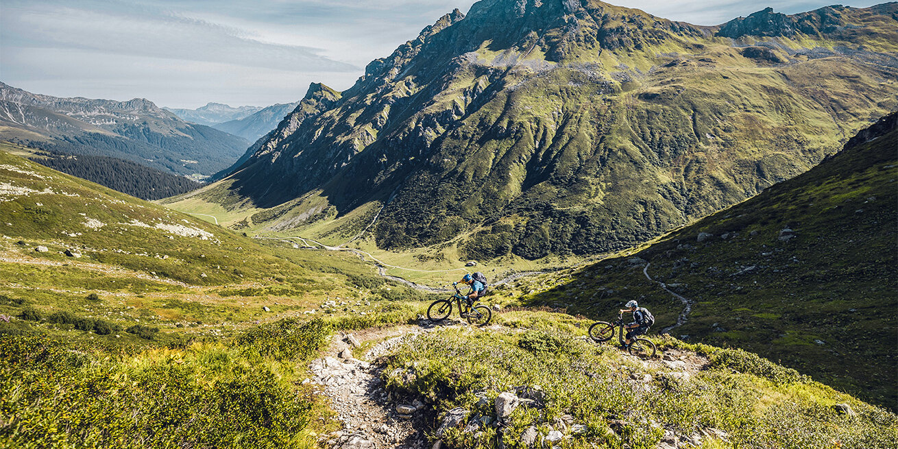 Two eBike riders on a rocky trail in the mountains