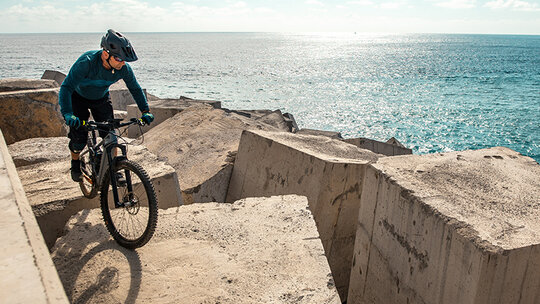 eBike rider on large cement blocks by the shore