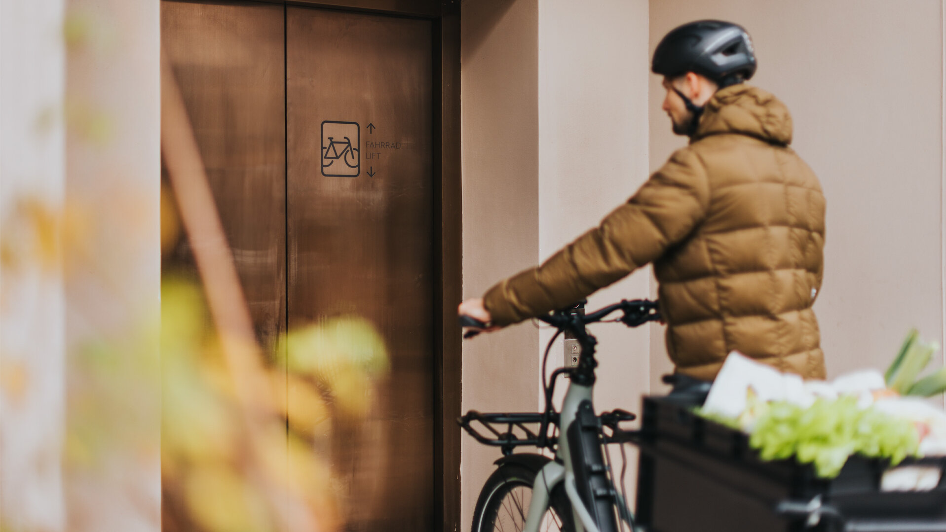 Ein Mann steht mit seinem vollbeladenen eCargo Bike vor einem Fahrradaufzug.