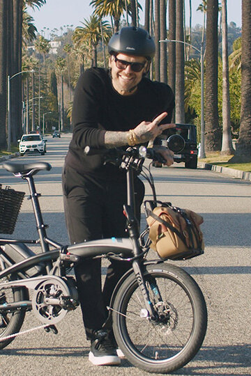 Bob Harper stands in the middle of a street, posing with his eBike.