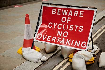 Un cartello che raccomanda di non sorpassare i ciclisti.