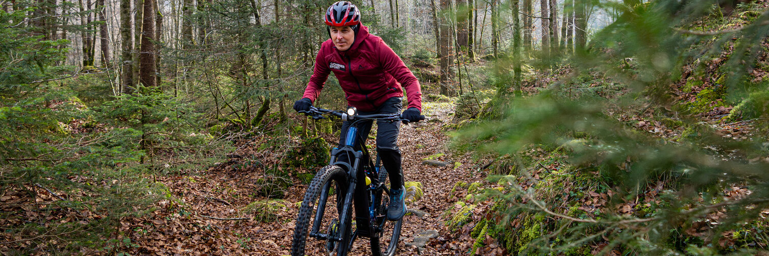 Viktor Röthlin fährt mit seinem eBike auf einem schmalen Pfad durch den Wald.