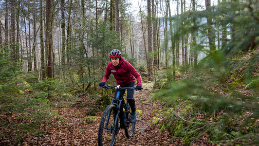 Viktor Röthlin fährt mit seinem eBike auf einem schmalen Pfad durch den Wald.