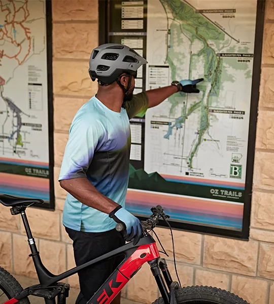 A mountain biker studies a trail map in Bentonville, Arkansas.