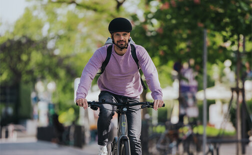 En elsyklist sykler i et område med redusert trafikk i et bymiljø.