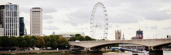 Een doorkijkje in Londen met zicht op een reuzenrad. 