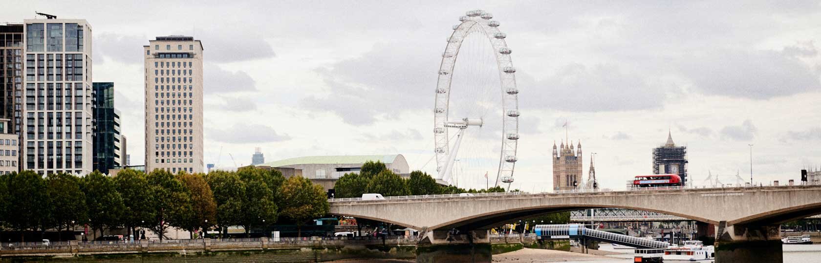 Widok na panoramę londyńskiej skyline z brzegu Tamizy, z London Eye i Big Benem w tle.