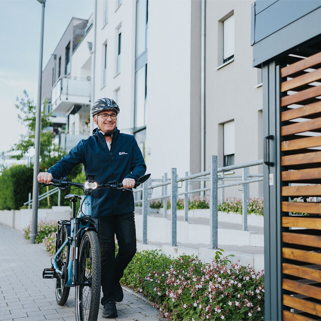Un uomo spinge la sua eBike su un marciapiede.