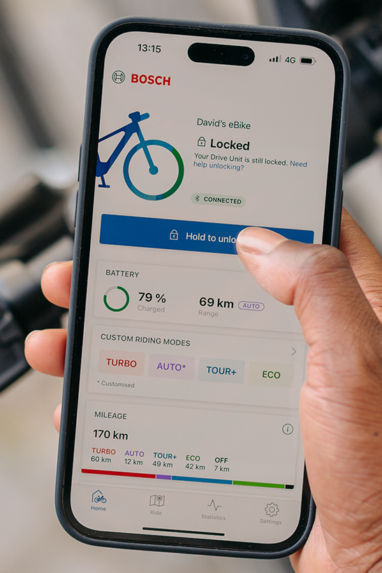 Een eBike-rijder houdt zijn smartphone in de hand en ontgrendelt zijn eBike met behulp van de eBike Flow-app.