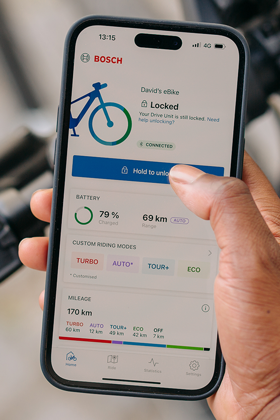 Un eBike piloto sostiene su teléfono en la mano y desbloquea su eBike con la ayuda de la aplicación eBike Flow.