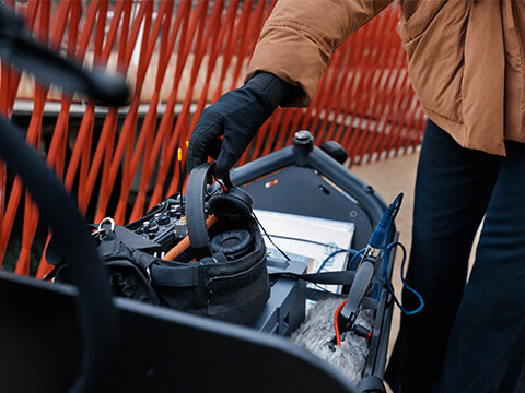 Someone takes their headphones out of a bag placed in the cargo basket of a Cargo eBike.