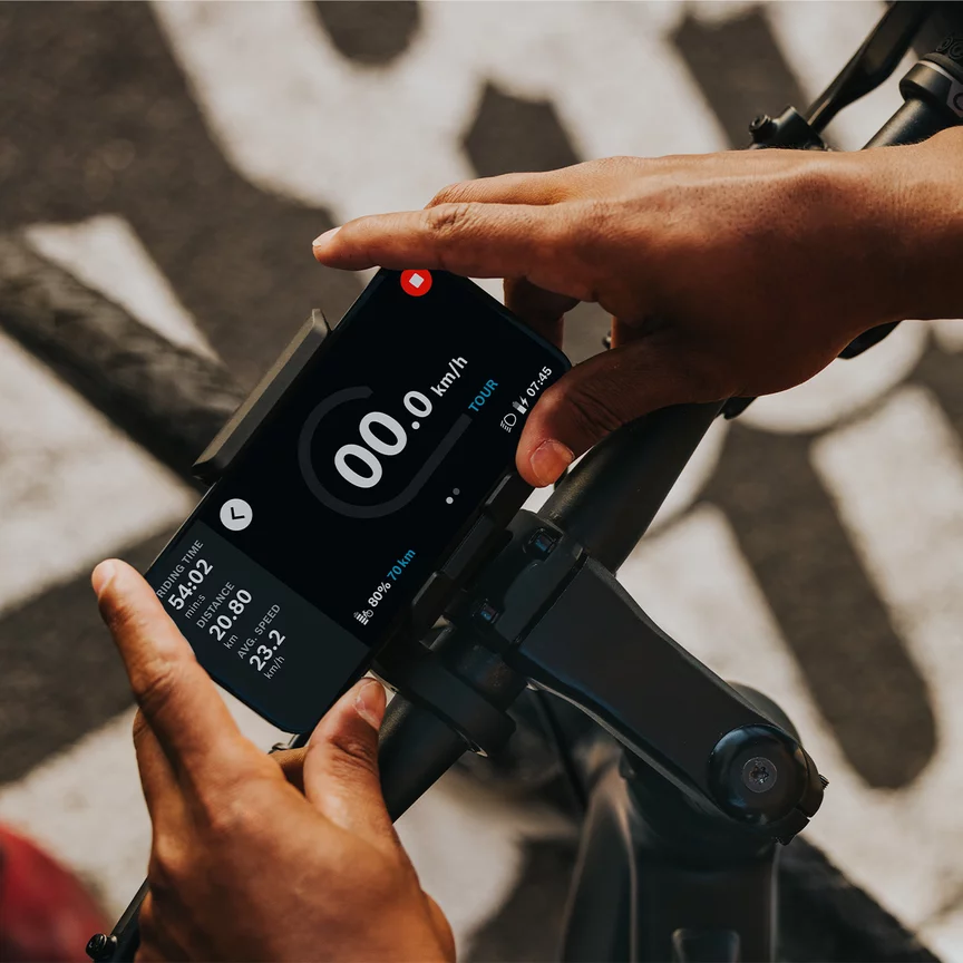 A person attaches his phone to a bicycle handlebar.