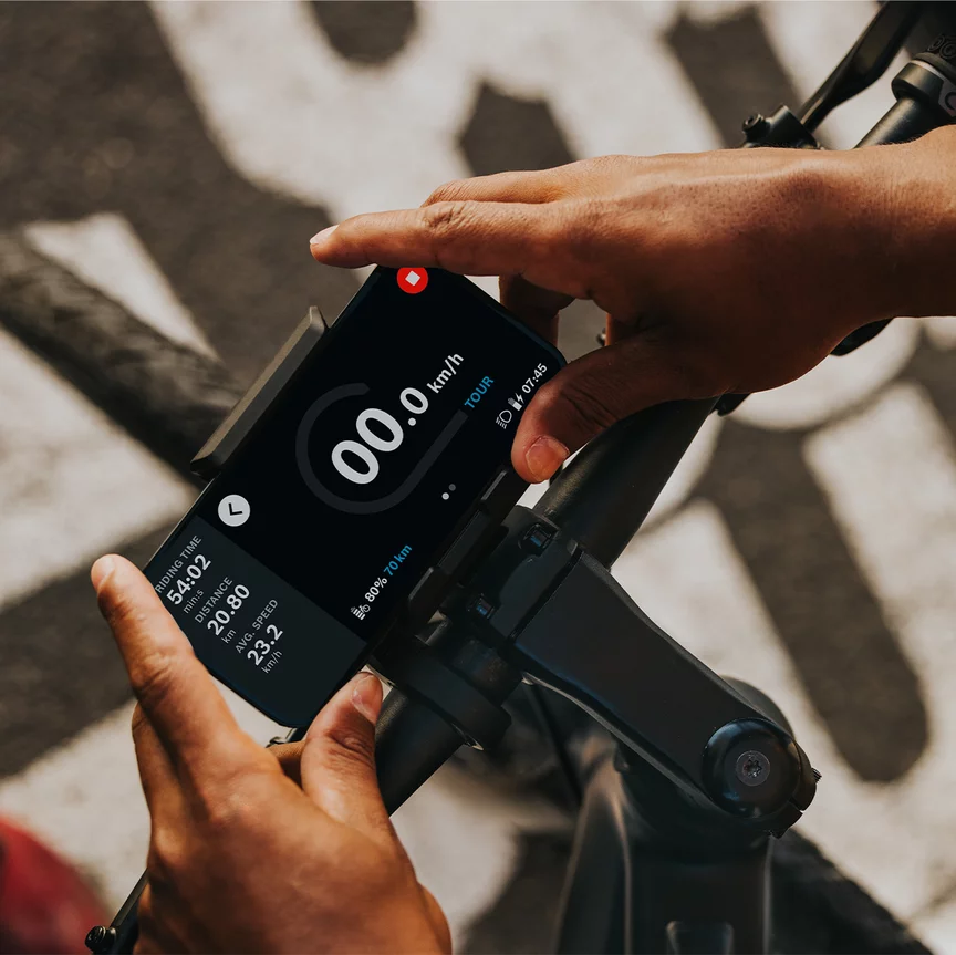 A person attaches his phone to a bicycle handlebar.