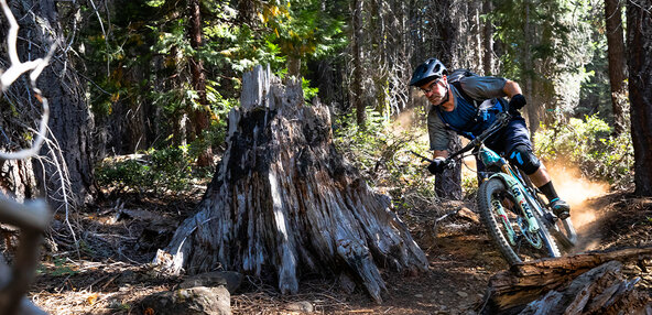 Rider on a eMTB going along a rough forest trail