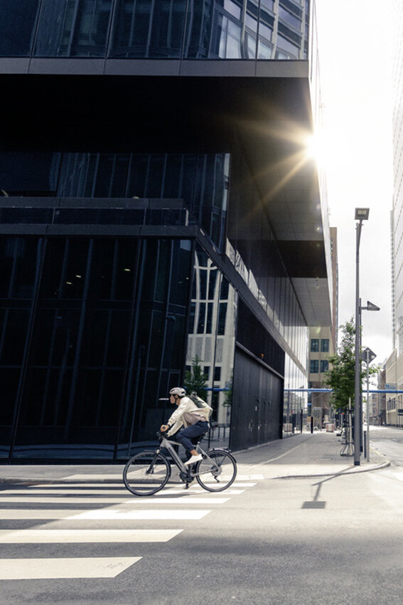 Man drives on his eBike through the streets of Frankfurt am Main, past modern buildings and urban architecture.