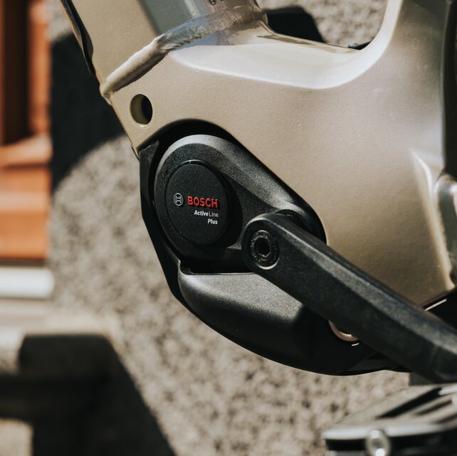 detailní záběr béžového elektrokola se zaměřením na Bosch motor Active Line Plus.