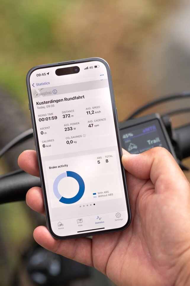 Close-up of a smartphone displaying statistics in the eBike Flow app.