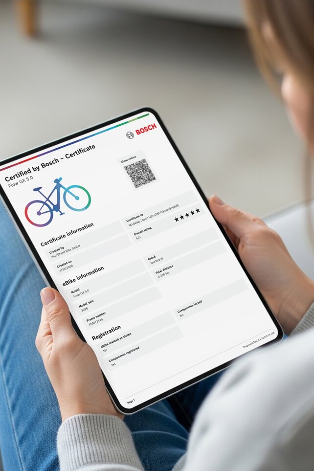 person som holder et nettbrett med digitalt «Certified by Bosch»-sertifikat for en Bosch-elsykkel.