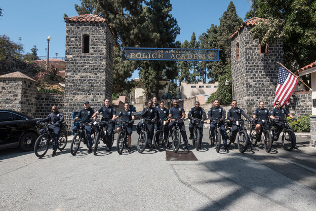 A group of LAPD police officers pose in front of the police academy with their eBikes.