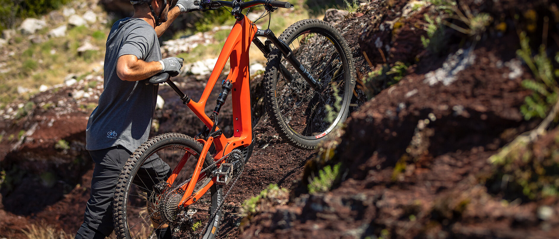 Un conducente di eMountain bike spinge la sua eBike su un pendio nel bosco.