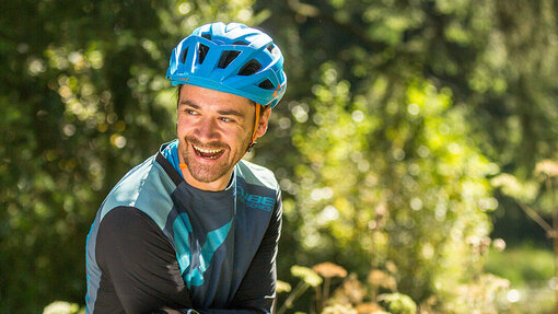 André Wagenknecht stützt sich lachend auf sein eMountainbike