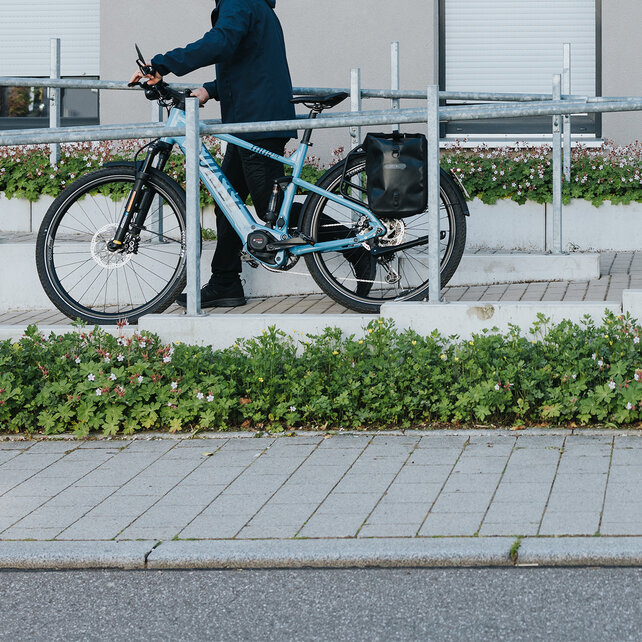 Man pushes his eBike down a ramp.