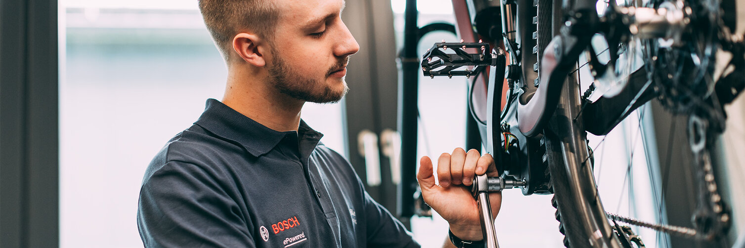 Fahrradmechaniker verwendet Werkzeug, um ein eBike zu reparieren.