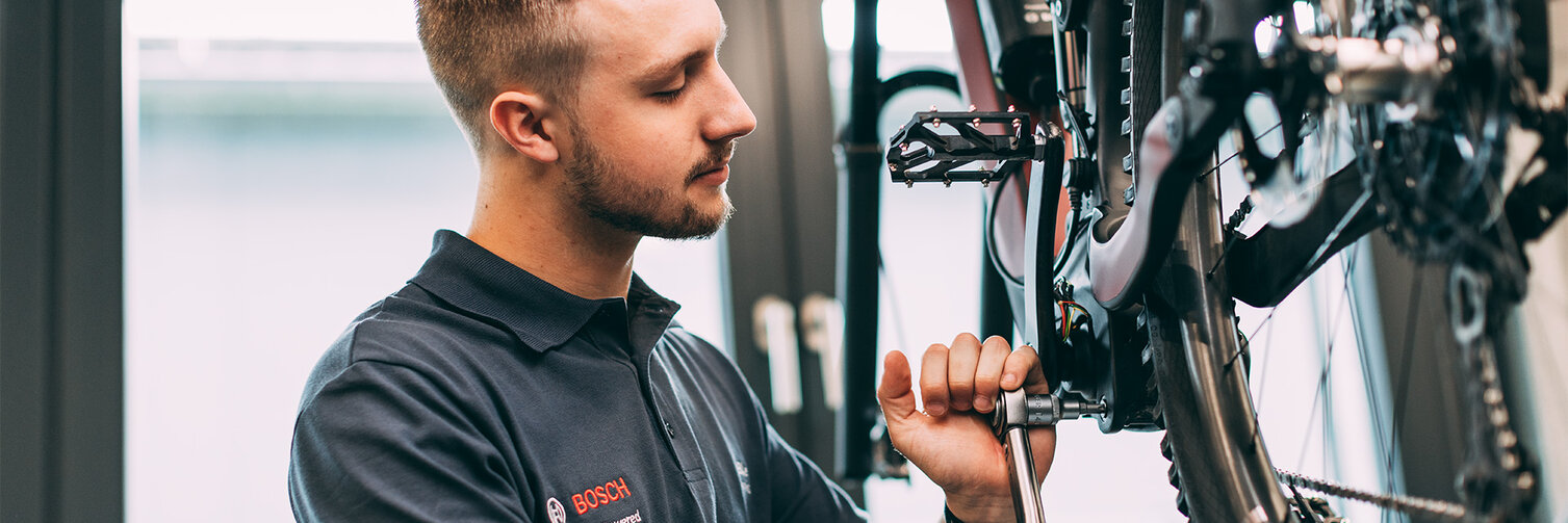 Fahrradmechaniker verwendet Werkzeug, um ein eBike zu reparieren.