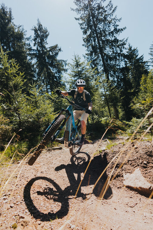 An eBiker performing a wheelie around the curve.
