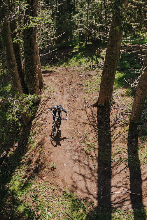An eBiker riding on a natural forest trail in South Tyrol.