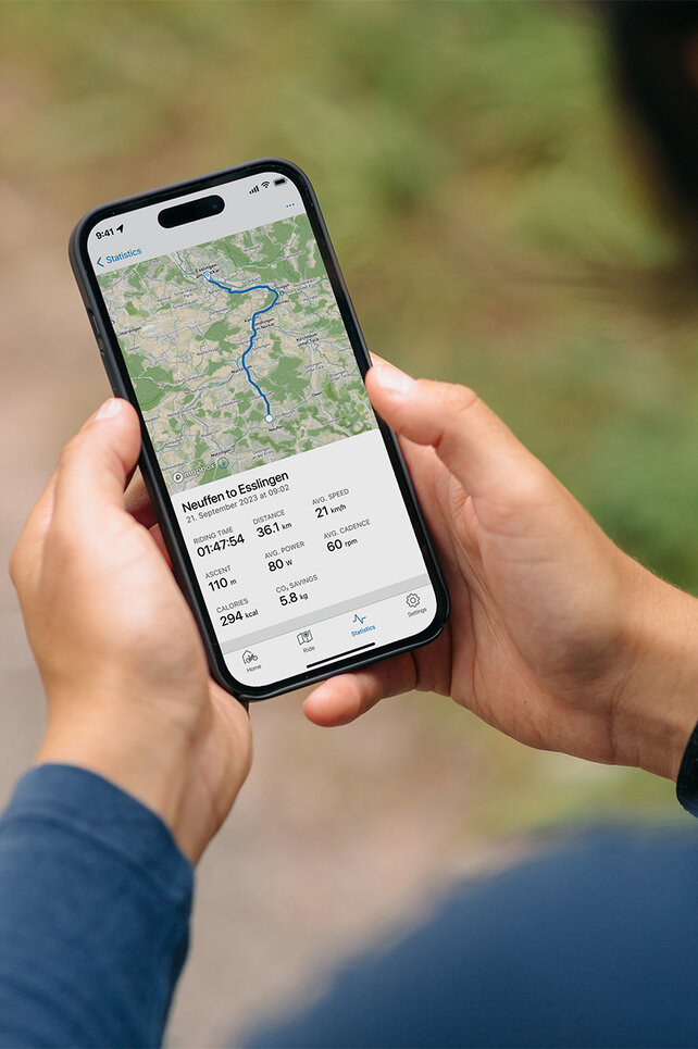 Guardando alle spalle di una persona che osserva il proprio percorso nell'app eBike Flow.