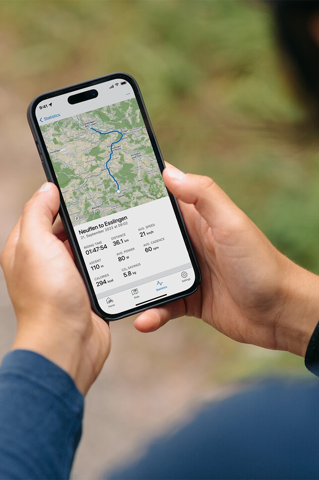 Ser over skulderen til en person som ser på ruten sin i eBike Flow-app.