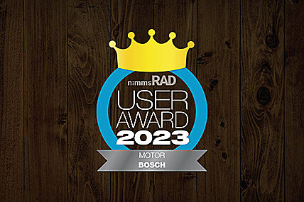 Icon with the text "nimms Rad User Award 2023 Motor Bosch": A golden crown above the text, enclosed by a blue circle. "MOTOR BOSCH" is written at the bottom. The background has a dark wood finish.