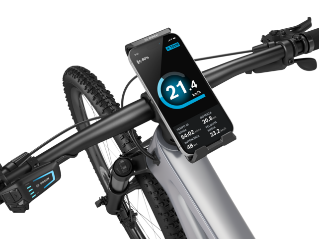 Dettaglio del manubrio di una eBike, dove al centro è posizionato un SmartphoneGrip Vertical con uno smartphone inserito.