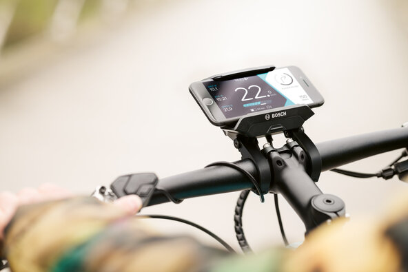 The mobile phone with the eBike Connect Smartphone app is attached to the handlebar