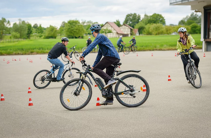 eBike-førere på en trafikkskole, som er utstyrt med trafikk-kjegler.