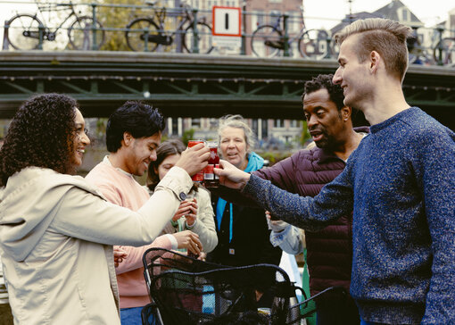 Een groep mensen proost samen met drankjes op een boot.