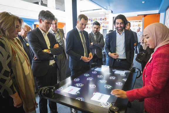 Een groep mensen staat rondom een groot touch display, waarop ook het Bosch-logo zichtbaar is. Ze verzamelen zich en gaan ermee aan de slag.