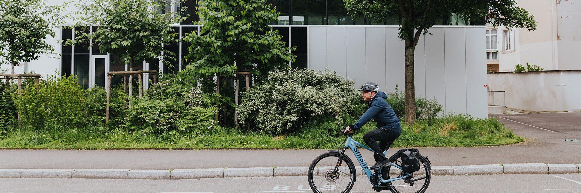 Un uomo percorre velocemente la sua eBike lungo una strada in una zona residenziale.