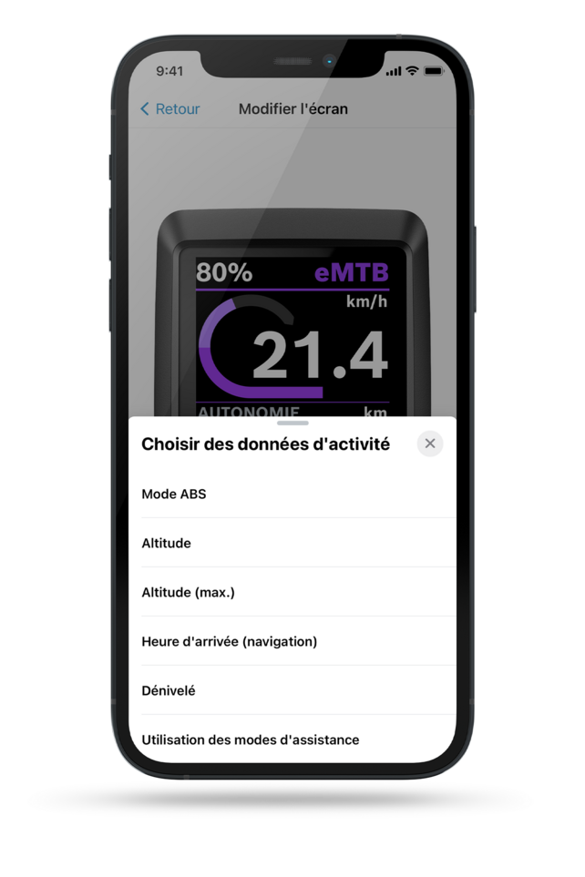 Capture d'écran d'un écran de smartphone montre un écran Kiox en arrière-plan, avec un menu affichant le texte 'Sélectionner les données d'activité'. Parmi les choix se trouvent le mode ABS, la batterie (VAE), la batterie (smartphone), l'heure d’arrivée (navigation), la montée, et le temps de freinage.