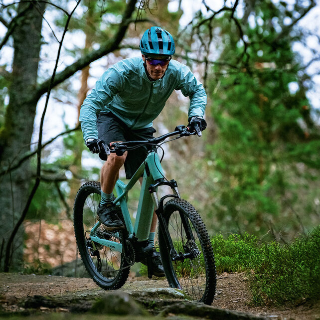 An eMountain bike rider drives down a forest pathlong.