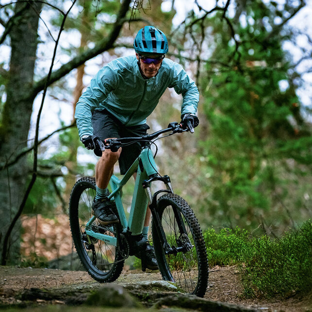 Ein eMountainbike Fahrer fährt einen Waldweg entlang.