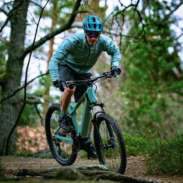 En mountainbikecyklist kör längs en skogsstig.